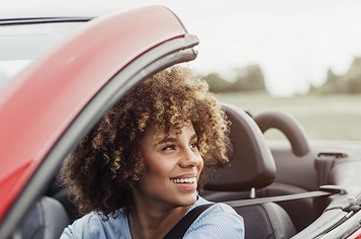 Woman driving a red convertible 