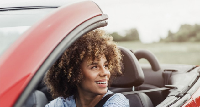 Woman driving a red convertible 