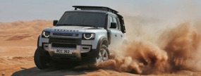 Landrover vehicle driving through sand