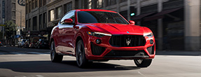 Red Maserati drives down a city street