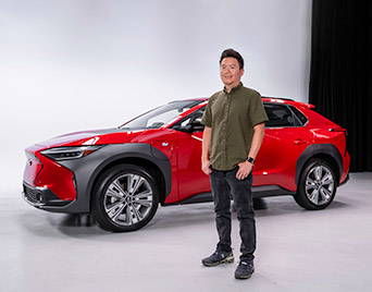 Subaru's Garrick Goh standing in front of a red Subaru Solterra