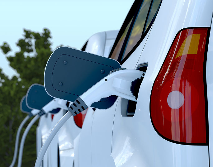 A close-up of a line of EVs charging