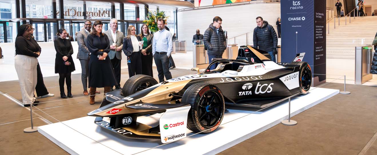 Jaguar Formula E displayed in showroom with viewers