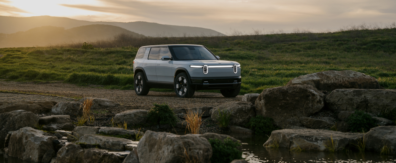 Rivian's latest electric mid-size SUV, the R2, parked in the wilderness