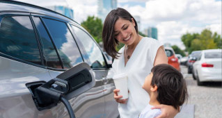 Mother and child smiling at each other while their electric vehicle charges