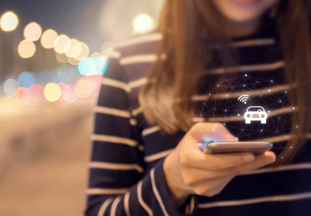 A woman using the bluetooth function on her phone to connect with her Rivian electric vehicle