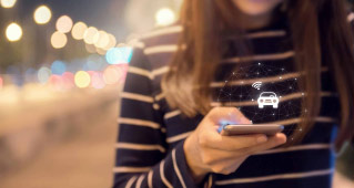 A woman using the bluetooth function on her phone to connect with her Rivian electric vehicle