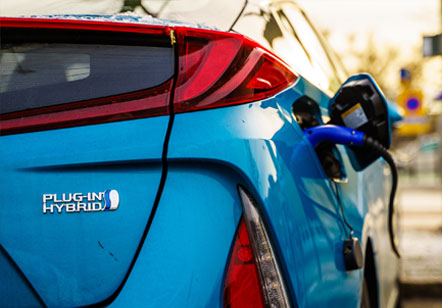 A 2023 Subaru Crosstrek Hybrid charging on the street