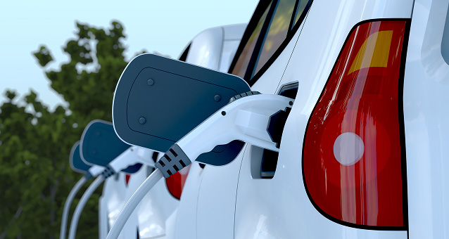 A close-up of a line of EVs charging