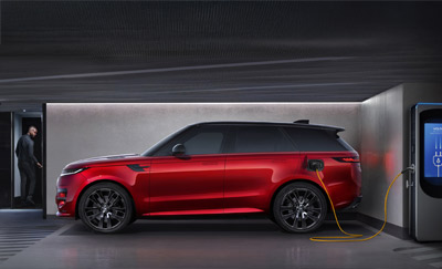 A side profile of a red Range Rover Sport PHEV charging