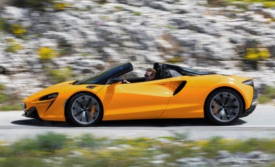 A McLaren Artura EV Spider driving through rocky terrain
